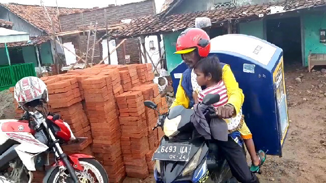 Duda beranak 2 Jualan Roti Keliling Sambil Gendong Anaknya Yang Lumpuh